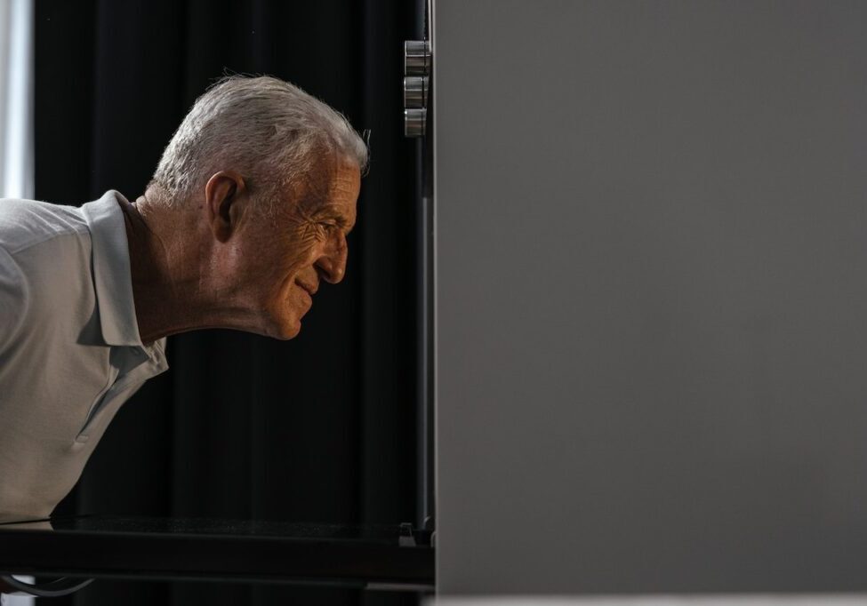 senior man looking at oven